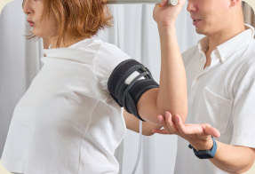 腕に加圧ベルトを巻いたトレーニングの様子